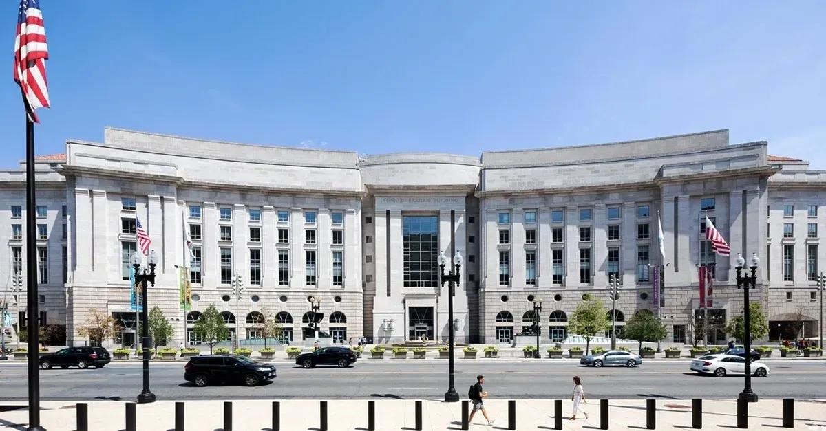 A large building with cars parked on the side of it.