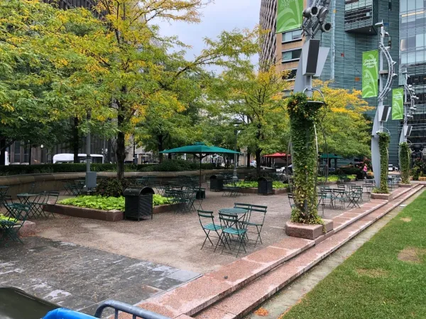 A park with benches and tables in the middle of it.