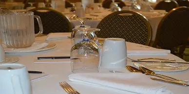 A table set with silverware and plates in front of a wine glass.