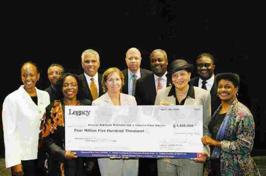A group of people holding up a large cheque.
